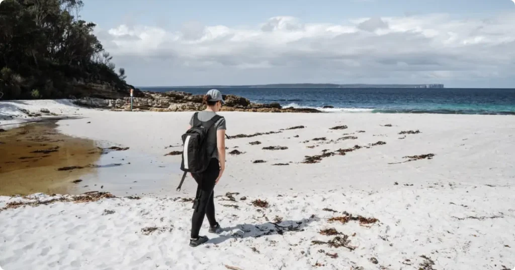 Australia Packing List: What to Pack for Every Season and Trip Length Open backpack with travel essentials including hat, sunscreen and water bottle for an Australia packing list