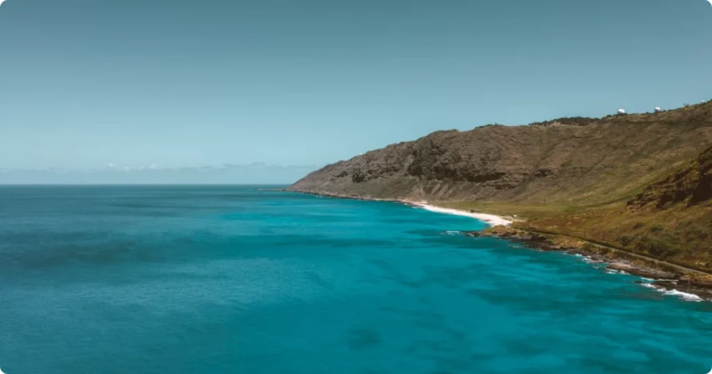 Best Beaches in Hawaii: Expert-Rated Picks by Island, Vibe and Experience Level Best beaches in Hawaii featuring crystal-clear turquoise water, white sand, and lush green mountains in the background