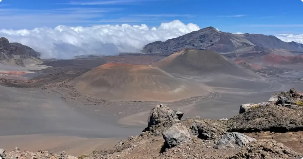 Haleakala Sunrise: A Complete Guide to Watching the Sunrise at Haleakala National Park Haleakala sunrise viewed from the summit crater at Haleakala National Park, Maui, with clouds below