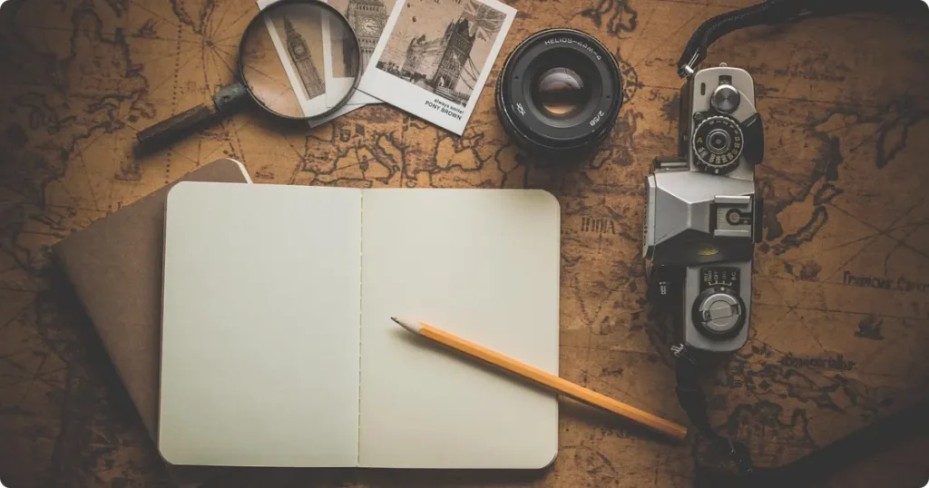 How to Plan a Trip: A Step-by-Step Guide for Every Destination and Budget Open map, notebook, and passport on a desk for trip planning