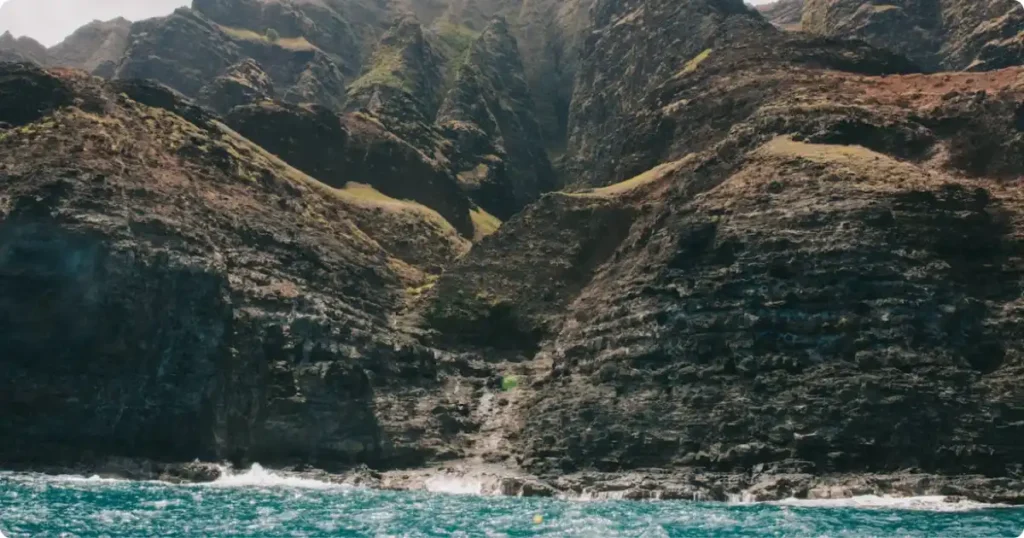 Na Pali Coast sea cliffs on Kauai, Hawaii — dramatic green coastline accessible on a budget