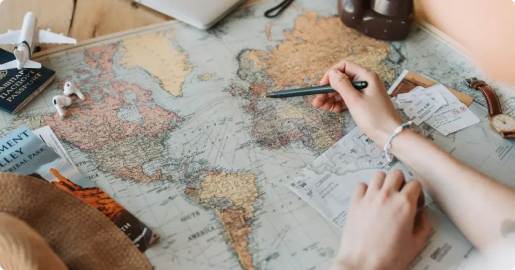The Complete Travel Planning Hub: Expert Guides, Tools and Resources for Every Type of Traveler Flat lay of a world map, notebook, and passport on a desk travel planning guide essentials